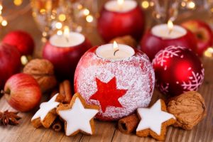 candles that look like apples surrounded by holiday treats