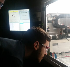 Researchers testing automated nanoparticle deposition procedures in an ultrasonic spray deposition system