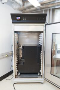 Open roll-away closet with electronics and equipment inside.